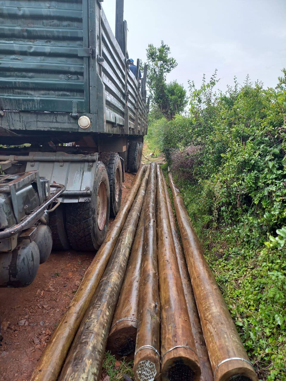 Electricity poles offloaded beside a truck ready for installation