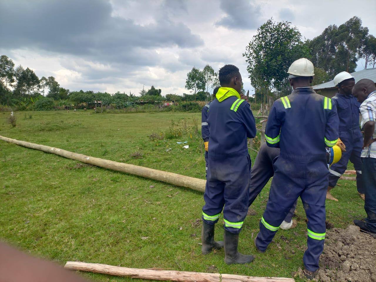Scabbard electrical crew in safety overalls preparing a power pole installation